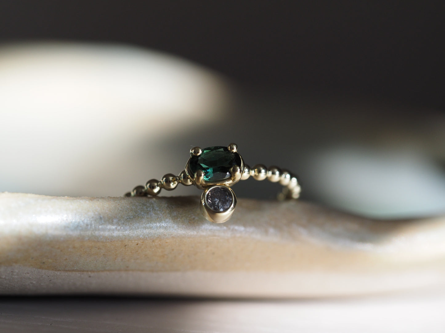 Gouden ring met ovale groene toermalijn en een zout & peper diamant