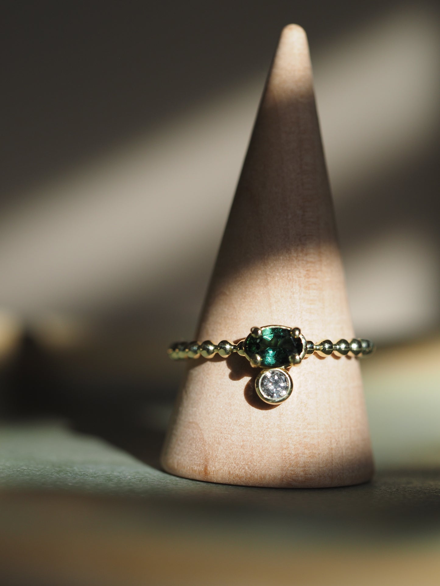 Gouden ring met ovale groene toermalijn en een zout & peper diamant