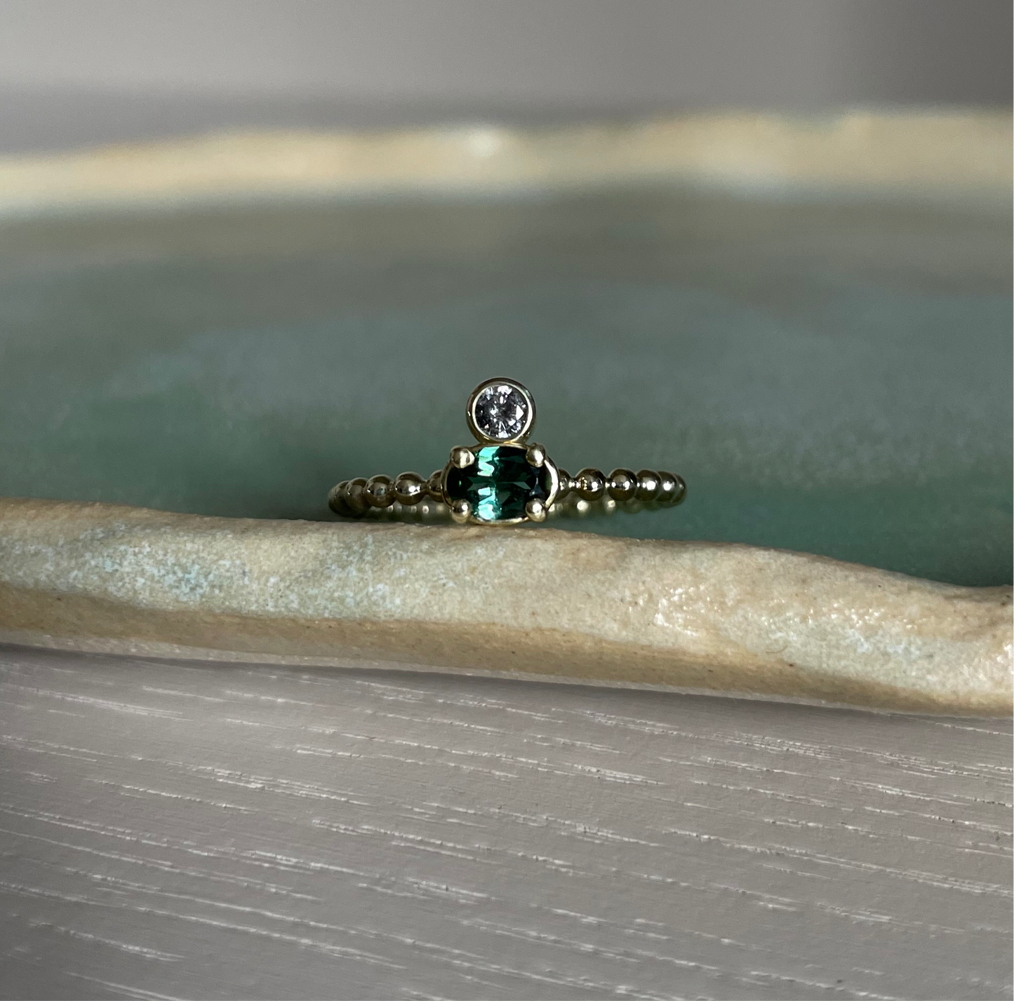 Gouden ring met ovale groene toermalijn en een zout & peper diamant