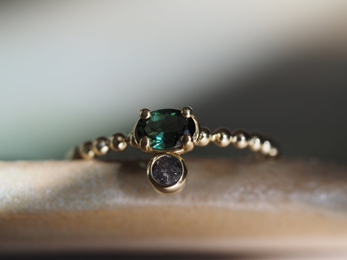 Gouden ring met ovale groene toermalijn en een zout & peper diamant
