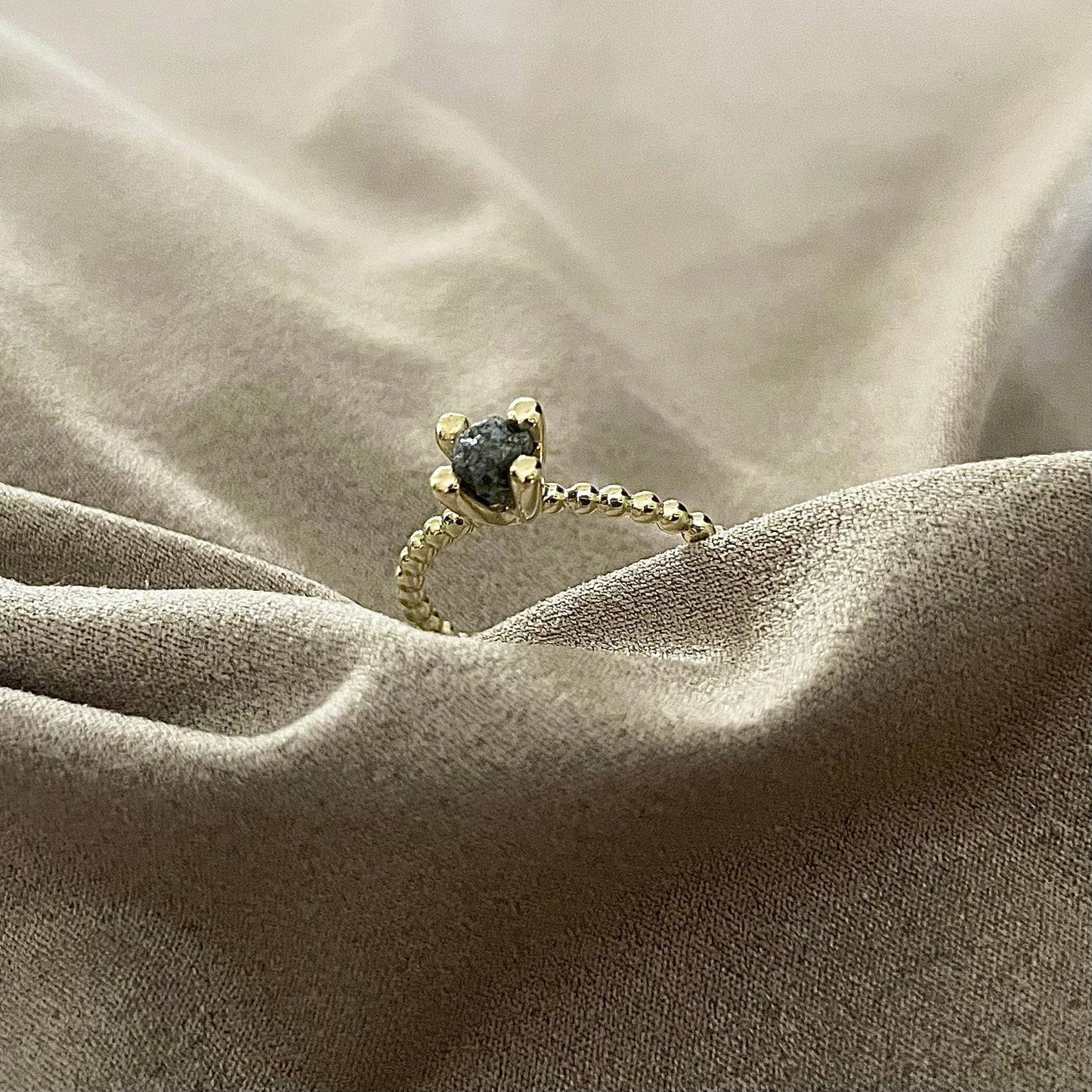 Gouden ring met bolletjes en donker grijze ruwe diamant